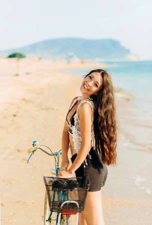 Charming girl in wedding dress standing on stone on sea backgroundの写真素材