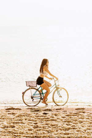 Charming girl in wedding dress standing on stone on sea backgroundの写真素材