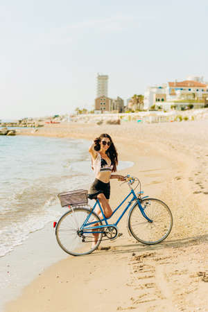 Charming girl in wedding dress standing on stone on sea backgroundの写真素材