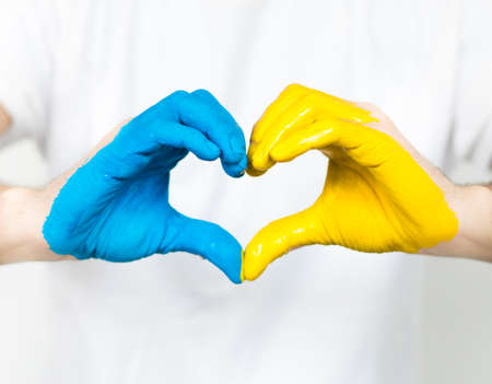 Love Ukraine concept. Hands in the shape of a heart are painted in the color of the flag of Ukraine - yellow and blue. selective focus. Independence Day of Ukraine, flagの写真素材