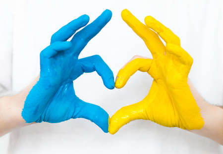 Love Ukraine concept. Hands in the shape of a heart are painted in the color of the flag of Ukraine - yellow and blue. selective focus. Independence Day of Ukraine, flagの写真素材