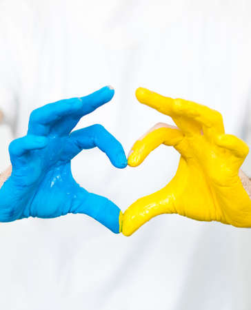 Love Ukraine concept. Hands in the shape of a heart are painted in the color of the flag of Ukraine - yellow and blue. selective focus. Independence Day of Ukraine, flagの写真素材