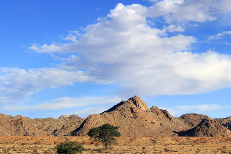 The bright blue sky above the mountainsの写真素材