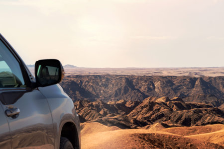 Close-up of a vehicle in the sand before a cliff.  Moon valley. Africa. Namibia