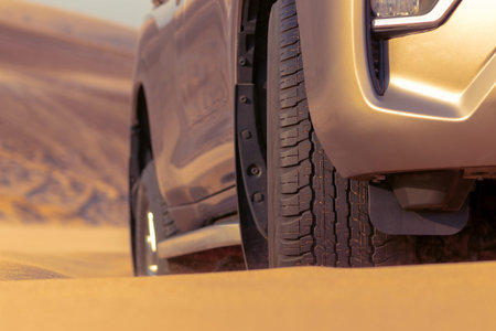 Close up of a golden car stuck in the sand in the Namib desert.