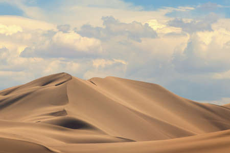 Golden sand dune 7 and white clouds on a sunny day in the Namib desert. Fantastic place for travelers and photographers.の写真素材