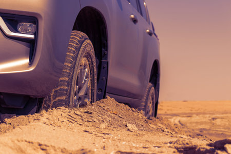Car wheels on a sea beach sand. Close-up of car wheel on sandy dunes. Car stuck in the sand....