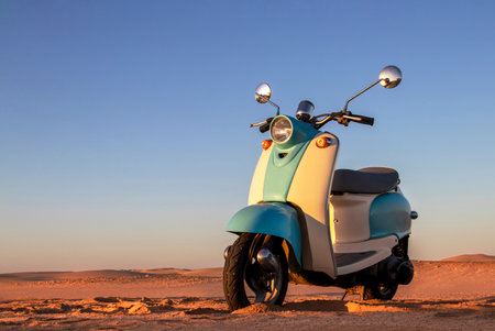 Retro blue scooter at sunset in the golden sand of the Namib Desertの写真素材