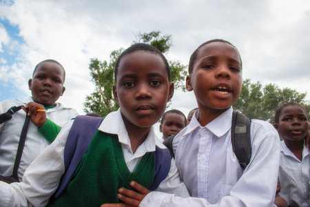Happy black African kids in school uniforms smiling and enjoying a break. A positive image of youth, education, diversity, and community spirit.の写真素材