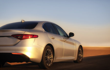 Silver vehicle seen from behind on a dusty Namibian road, blending modern design with rugged desert terrain. Ideal for travel, automotive, and editorial themes.の写真素材