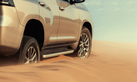 Close-up of an off-road vehicle stuck in deep sand in the Namib Desert, Namibia. Captures real...