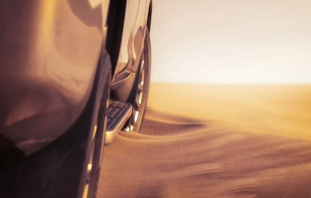Detailed view of a car stuck in thick desert sand, emphasizing power, resistance, and the harsh beauty of nature. Great for editorial, auto, and adventure content.の写真素材