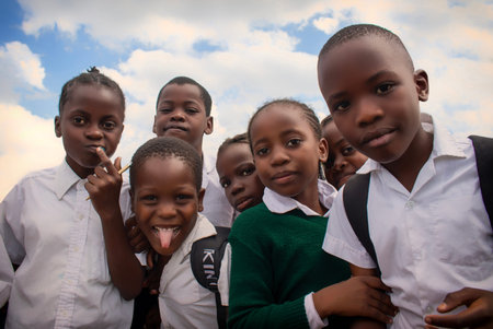 Real photo of cheerful African kids in school uniforms, enjoying time together outdoors. A natural...
