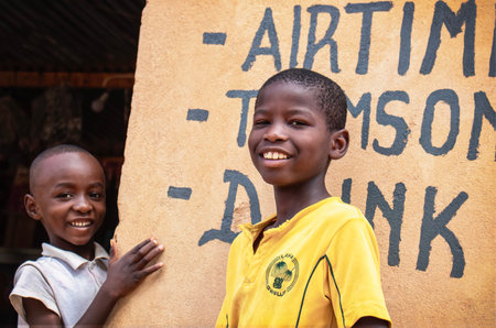 Two young African boys in a Namibian refugee camp, standing quietly against a weathered wall. A powerful image of innocence, hope, and life in humanitarian settings.の写真素材