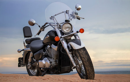 A dirt bike parked alone in the open desert, framed by stormy clouds. Perfect for themes of solitude, adrenaline, and rugged exploration on two wheels.の写真素材