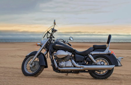 A dirt bike parked alone in the open desert, framed by stormy clouds. Perfect for themes of...