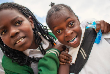 Premium close-up of happy African schoolchildren in uniforms, laughing together outdoors. A powerful and uplifting image capturing real joy, childhood, and cultural connection.の写真素材