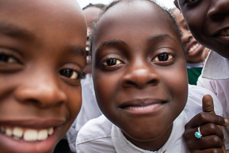 Premium close-up of happy African schoolchildren in uniforms, laughing together outdoors. A powerful and uplifting image capturing real joy, childhood, and cultural connection.の写真素材