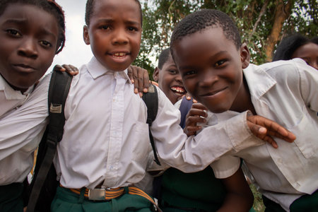 Premium close-up of happy African schoolchildren in uniforms, laughing together outdoors. A powerful and uplifting image capturing real joy, childhood, and cultural connection.の写真素材