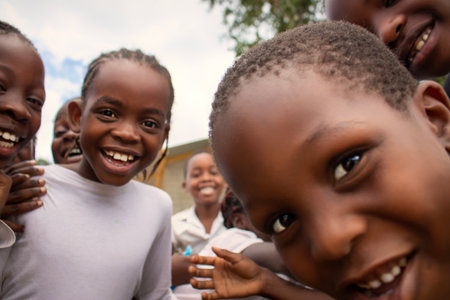 Premium close-up of happy African schoolchildren in uniforms, laughing together outdoors. A powerful and uplifting image capturing real joy, childhood, and cultural connection.の写真素材