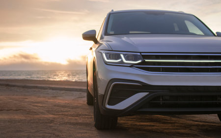 Gray Vehicle Near the Shoreline at Golden Hour â Exclusive Image Highlighting Adventure, Style, and the Tranquil Beauty of Driving Along the Coastline at Dusk.の写真素材