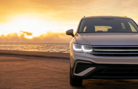 Gray Vehicle Near the Shoreline at Golden Hour â Exclusive Image Highlighting Adventure, Style, and the Tranquil Beauty of Driving Along the Coastline at Dusk.の写真素材