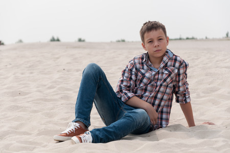 Stylish teenager sitting on the beachの写真素材