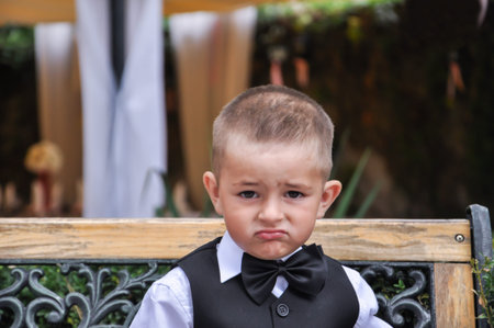 baby gentleman in a suit with a butterfly sitting on a bench