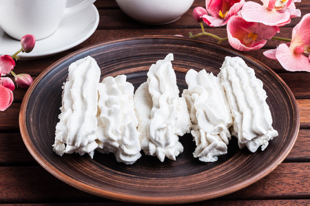 White marshmallows and coffee on a wooden the trayの写真素材