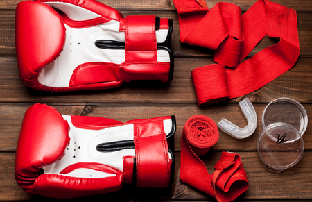 Red leather gloves for boxing and of Kickboxing on wooden boardsの写真素材