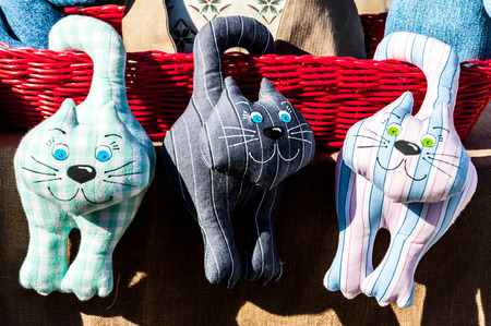 Three kittens of various colors of cloth hanging on the basketの写真素材