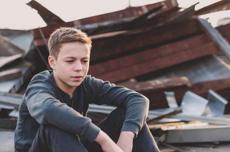 Lonely teenager sitting on roof the houseの写真素材