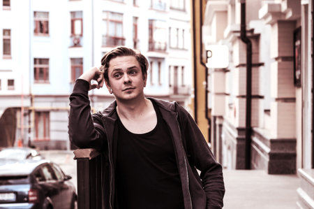 young attractive man near the wall of house