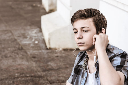 rapt teenager with a tablet sitting near the wallの写真素材