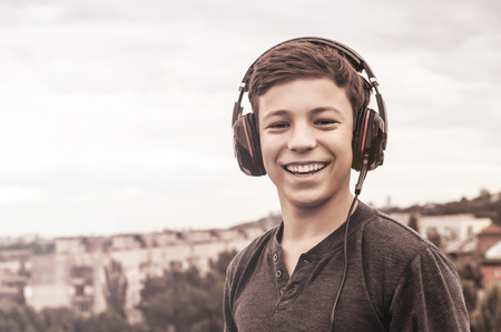 teenager on the roof of the house listens to musicの写真素材