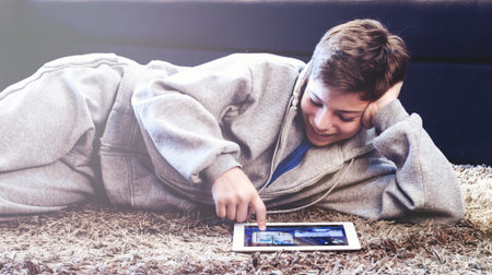 teenager with tablet while lying on the floor in the room
