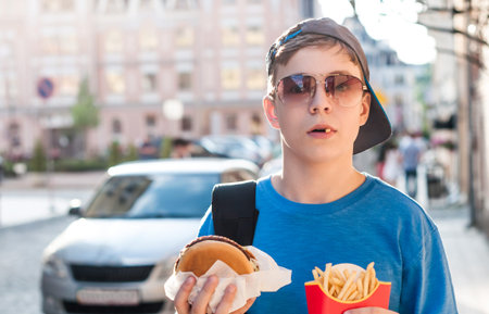 teenager on a city street with food in the hands