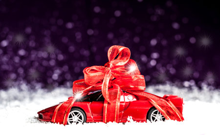small car with red decorative bow in snow