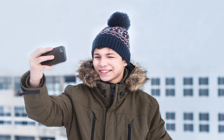 young man in winter on a city street on a frosty dayの写真素材