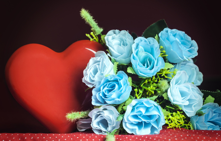bouquet of blue roses and a large red heart on the tableの写真素材