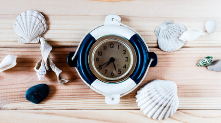 Decorative marine clock Lifebuoy on the background of wooden boards