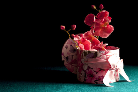 Decorative gift box with orchids on a dark green backgroundの写真素材