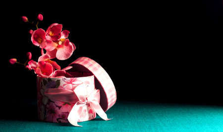 Decorative gift box with orchids on a dark green background