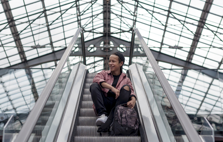 young man standing on an escalator rises upの写真素材