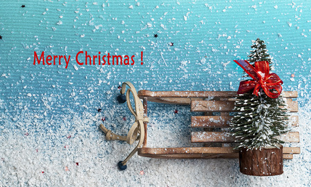 Christmas tree with bow on wooden sleigh on a blue backgroundの写真素材