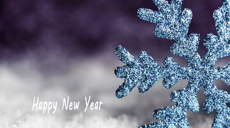 blue snowflake in the snow on a snowy backgroundの写真素材