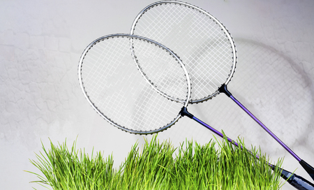 badminton rackets against a brick wall background, green grassの写真素材