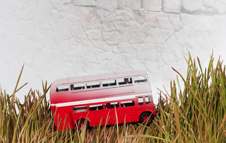 small red decorative bus on brick wall backgroundの写真素材