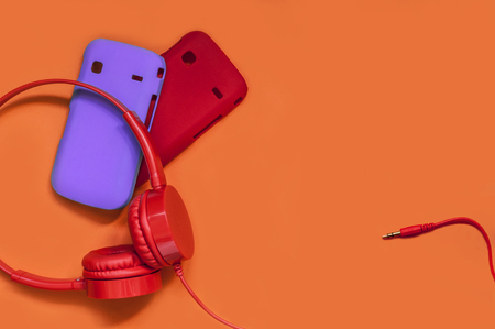 stylish headphones and cases for your phone on an orange backgroundの写真素材