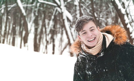 happy young man in the park in winterの写真素材